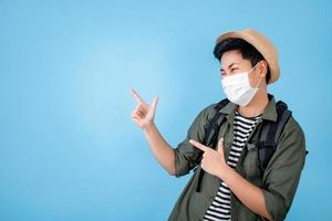 Tourists wear medical masks to stop spreading the virus and point to empty spaces on the blue ground. photo