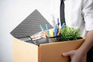 Fired from work. The picture of a business man with a box on a white background. photo