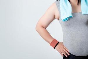 Side of the overweight woman wearing workout on white background with copy space. Health care concept. photo