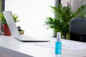 Closeup, disinfectant alcohol spray on the office desk photo