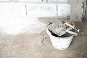 Cement in the tank with plastering the house wall on the construction site photo