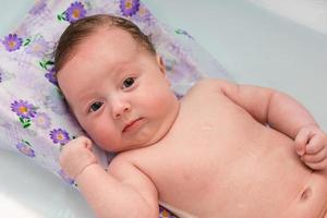 el bebe esta bañado en el baño foto