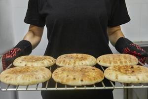 Chef keeps the pita on the wire rack after being baked in the electric oven photo