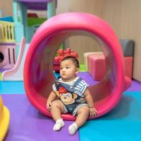 Child sitting and playing with toy smiling looking cute Focusing only on the child in the center of the picture There is a slight blur in the surrounding area intended to provide images with depth photo