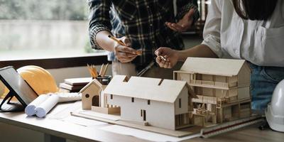 reunión de trabajo en equipo de ingenieros, trabajo de dibujo en la reunión de planos para el trabajo del proyecto con un socio en la construcción de modelos y herramientas de ingeniería en el concepto de sitio de trabajo, construcción y estructura. foto