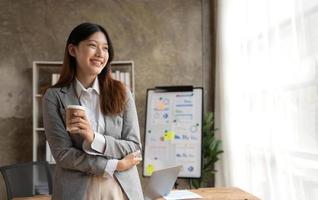 Beautiful Asian businesswoman crossed arms at the office looking at the window. photo