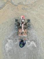 Aerial top down view farmer use tractor to plowing paddy photo