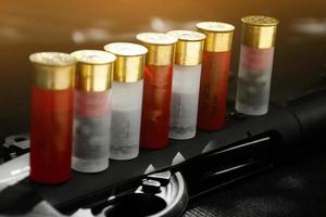 Shotshell bullets near shotgun, soft and selective focus. photo