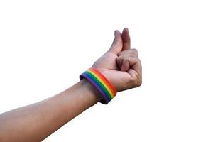 Hand of human which has rainbow wristband and doing mini heart or love sign by fingers, concept for presenting love to LGBTQ genders to all people who had gender diversity around the world. photo