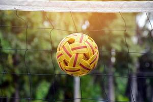 pelota sepak takraw en la red, enfoque suave y selectivo en la pelota, juego al aire libre sepak takraw después de la escuela y después del concepto de trabajo. foto