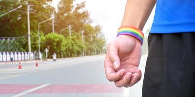 Rainbow wristband on right and left hand, soft and selective focus photo