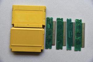 Electronic cartridge board for retro game console. A yellow plastic cartridge on a black background and an electronic board. photo