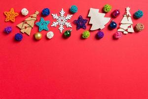 Top view of holiday decorations and toys on red background. Christmas ornament concept with empty space for your design photo