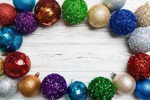Top view of frame made of decorative balls on wooden background. Christmas toys concept with empty space for your design photo