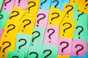 Question marks background. Colorful paper notes with question marks. Concept image. Closeup top view toned photo