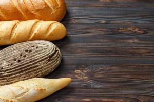 Bakery background, bread assortment on black wooden backdrop. Top view with copy space photo