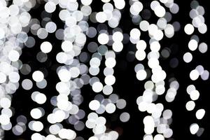 Abstract bokeh of white lights on black background. defocused and blurred many round light photo