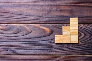 A wooden blocks cube over black wooden textured background with copy space for add word text title. Concept or conceptual Wood block stair or three steps. Cubic photo