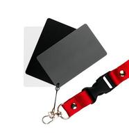 Three cards, one white, one grey and one black, attached together, and on a red strap, on a white surface. isolated on white background photo