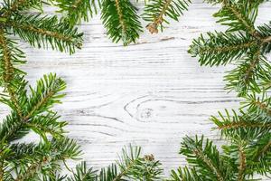 Round frame made of Christmas pine tree branches on old wooden board. Space for text. Top view photo