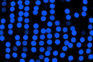 Unfocused abstract dark blue bokeh on black background. defocused and blurred many round light photo