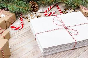 Parcel in Envelope with Fir-tree Branches and christmas decoration on a Wooden Background photo