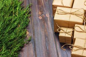 Christmas fir tree branches with gift box on dark rustic wooden background with copy space for text photo