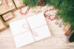 Parcel in Envelope with Fir-tree Branches and christmas decoration on a Wooden Background. Toned photo