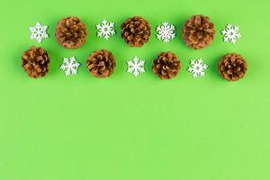 Top view of holiday composition made of pine cones and white snowflakes on colorful background. Winter time and Christmas concept with copy space photo