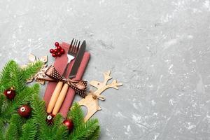 Top view of flatware tied up with ribbon on napkin on cement background. Christmas decorations and reindeer with empty space for your design. New Year holiday concept photo