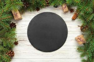 top view. Empty black slate plate on wooden christmas background. holiday dinner dish concept with new year decor photo