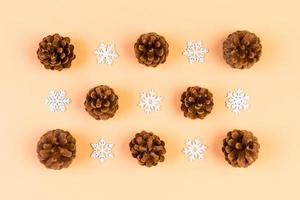 Top view of holiday composition made of pine cones and white snowflakes on colorful background. Winter time and Christmas concept with copy space photo