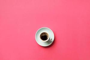 Blue cup of coffee on a colorful pink background. top view with copy space. morning concept photo