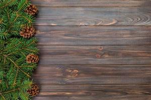 Christmas gray wooden background with fir tree frame and cones copy space. top view empty space for your design photo