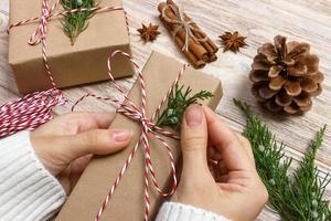 Hands of woman decorating Christmas gift box photo