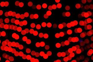 Bokeh rojo abstracto desenfocado sobre fondo negro. desenfocado y borroso muchas luces redondas foto