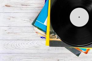 Pile of old vinyl records on wooden background photo