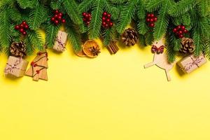 vista superior de las decoraciones navideñas sobre fondo amarillo. concepto de vacaciones de año nuevo con espacio de copia foto