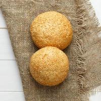 baked bun with sesame seeds lying on fabric photo