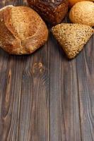 Bakery background, bread assortment on black wooden backdrop. Top view with copy space photo