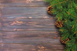 Christmas gray wooden background with fir tree frame and cones copy space. top view empty space for your design photo