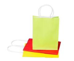 a green package of recycled paper stands on folded red and yellow packages photo
