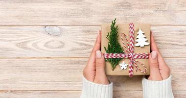 gift box wrapped in recycled paper, with ribbon bow, banner with ribbon on rustic background photo
