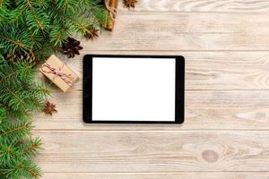 Digital tablet mock up with rustic Christmas wooden background decorations for app presentation. top view with copy space photo