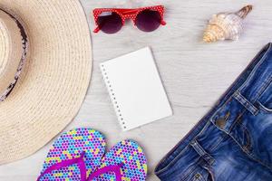 sombrero de mujer de playa de paja gafas de sol vista superior pantalones cortos de concha chanclas con espacio para texto. foto