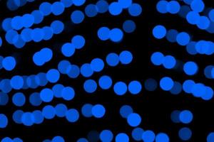 Unfocused abstract dark blue bokeh on black background. defocused and blurred many round light photo