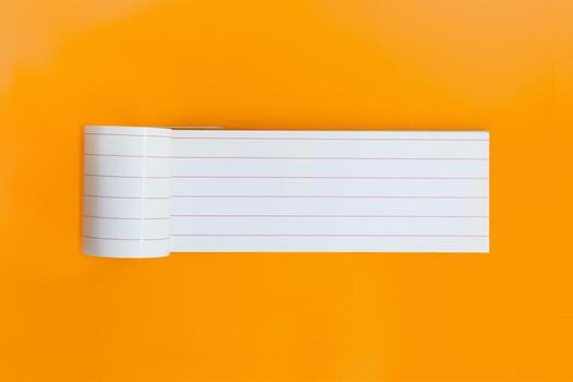 Long empty notebook for text on orange background. Open planner sheet, reminder. Copy space photo