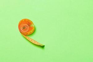 Tangled measuring tape with space for your idea. Sewing and tailor concept on green background photo