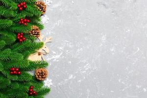 Top view of Christmas background made of fir tree and decorations on cement background. New year holiday concept with copy space photo