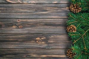 Christmas vintage, toned gray wooden background with fir tree frame and cones copy space. top view empty space for your design photo